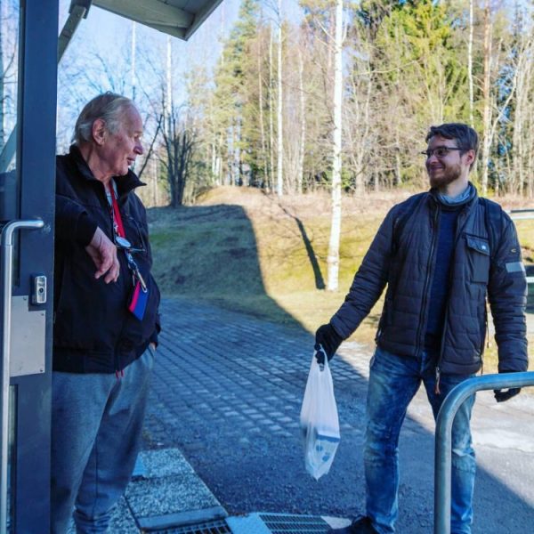 Hanketyöntekijä viemässä ruokakassia iäkkäälle.