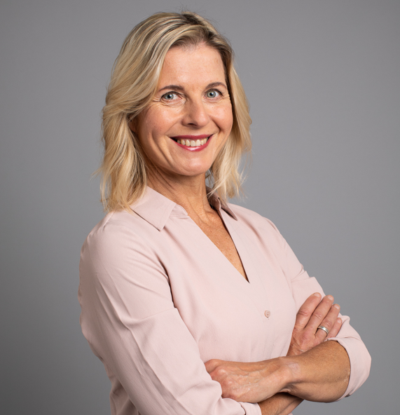 JAana Rossi, vaaleat pitkähköt hiukset, roosa paita, katsoo kameraan. 