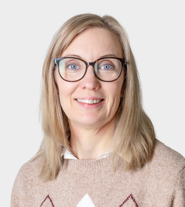 Katri, vaaleat puolipitkät hiukset, silmälasit, katsoo kameraan. 