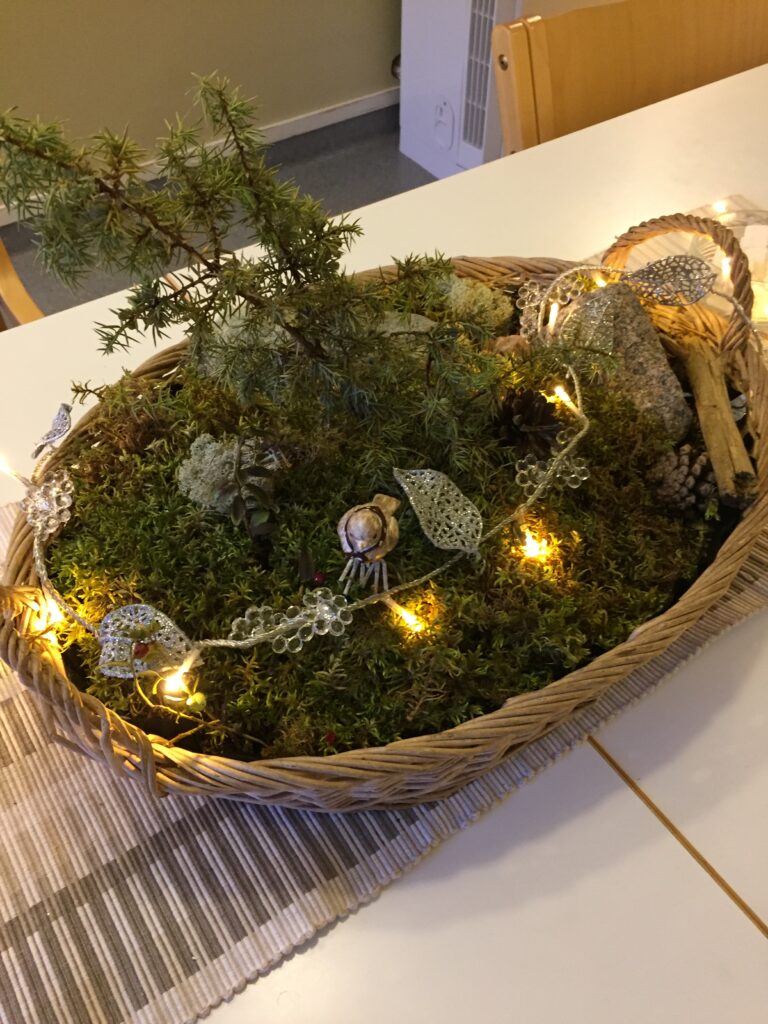 Luonnonmateriaaleista rakennettu jouluasetelma.