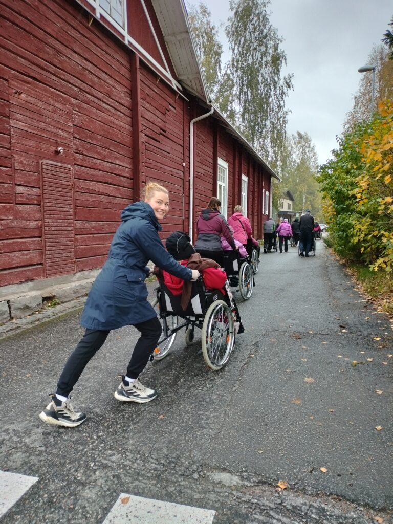 Syksyinen katu, punaisia isoja rakennuksia vasemmalla.