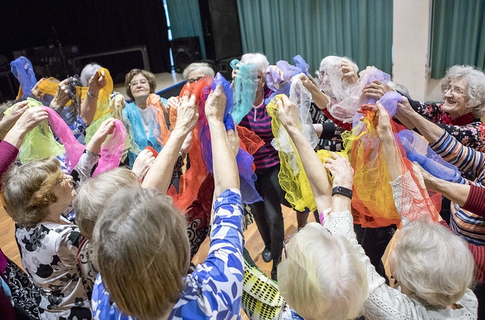 Senioritanssijoita kerääntyneenä yhteen värikkäiden huivien kanssa.
